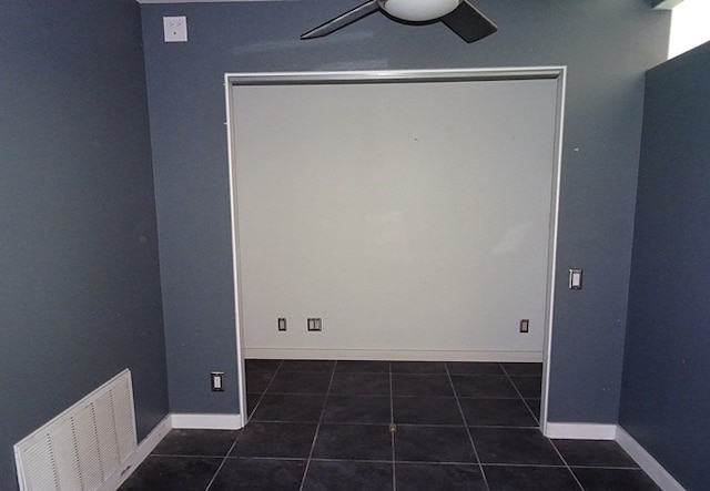 tiled empty room featuring ceiling fan