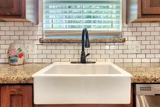 details featuring sink, stainless steel dishwasher, and backsplash