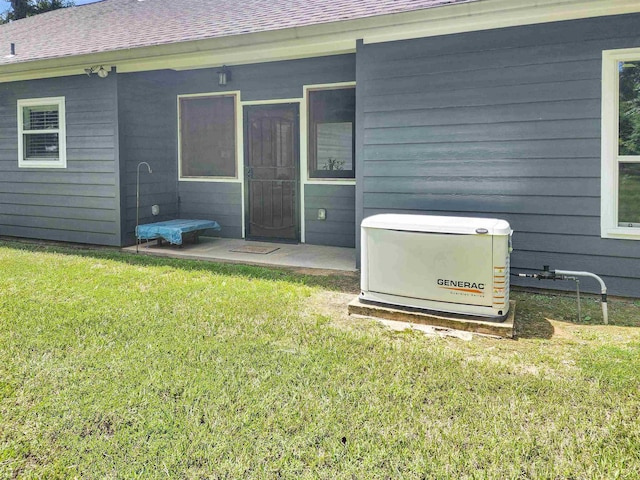 back of property featuring a shingled roof and a yard