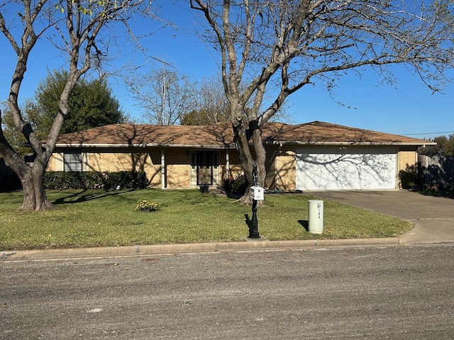 ranch-style house featuring a garage and a front lawn