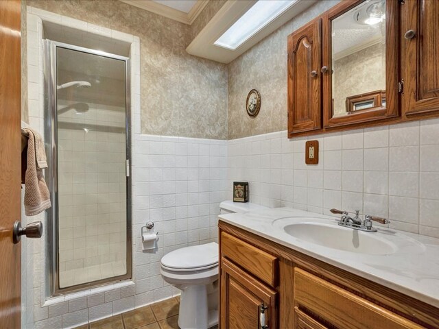 bathroom featuring vanity, crown molding, tile patterned flooring, toilet, and an enclosed shower