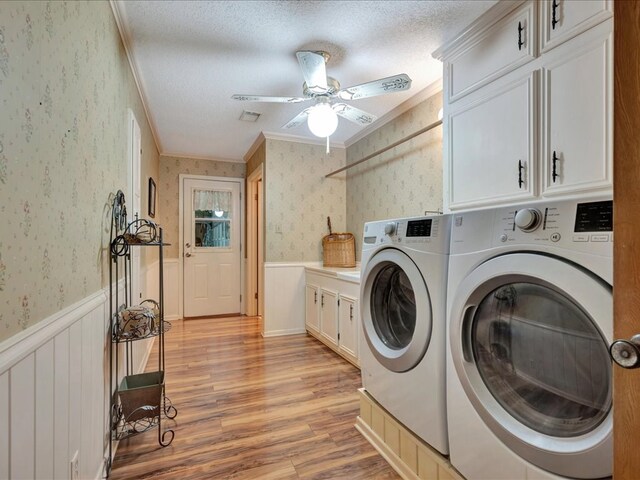 laundry room featuring washing machine and clothes dryer, cabinets, crown molding, light hardwood / wood-style floors, and a textured ceiling