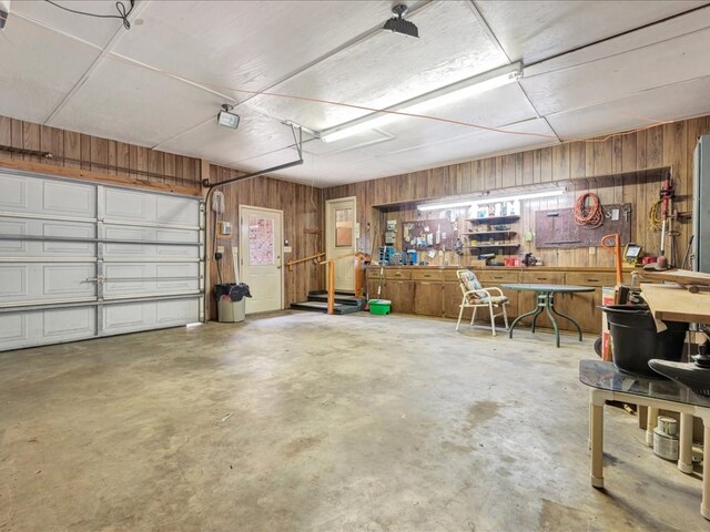 garage with a workshop area and wood walls