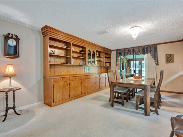 carpeted dining room with a textured ceiling and crown molding