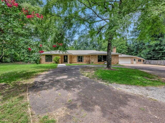 ranch-style house with a garage and a front yard