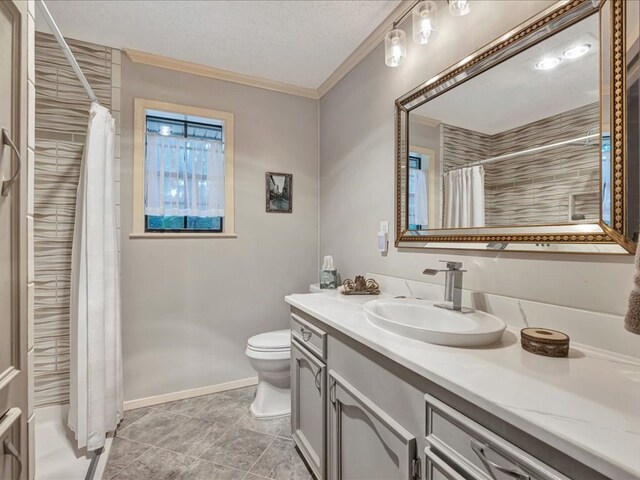 bathroom with tile patterned flooring, a textured ceiling, toilet, vanity, and ornamental molding