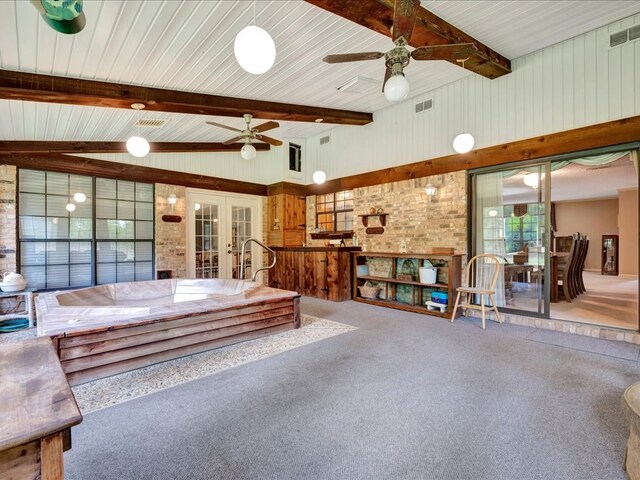 interior space featuring beam ceiling, carpet floors, a wealth of natural light, and french doors