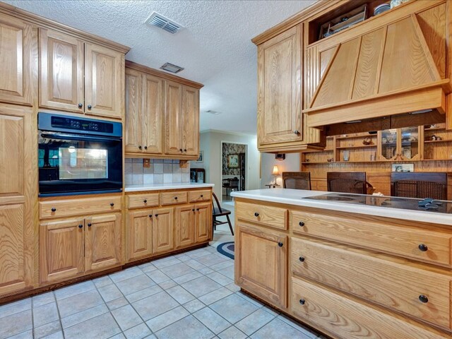 kitchen featuring backsplash, custom range hood, cooktop, light tile patterned floors, and oven