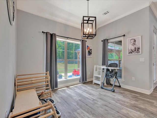 interior space featuring crown molding, light hardwood / wood-style flooring, and a notable chandelier