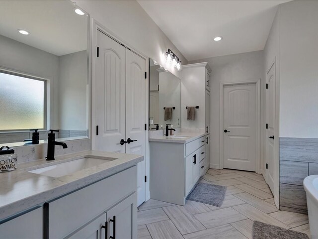 bathroom with a washtub and vanity