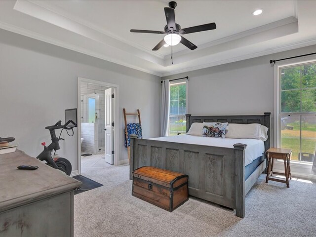 bedroom with a tray ceiling, multiple windows, ceiling fan, and light colored carpet