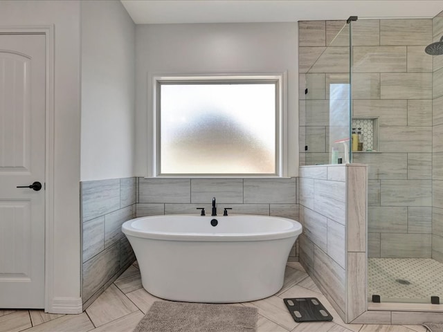 bathroom featuring separate shower and tub, tile patterned floors, and tile walls