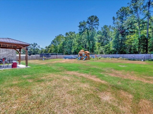 view of yard featuring a playground, a gazebo, a patio, and a trampoline