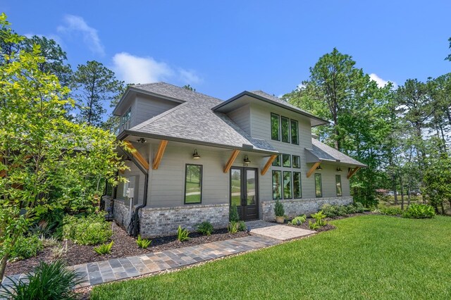 373 Duffer Dr, Brookeland, TX 75931 - modern home with french doors, a front lawn, and a shingled roof