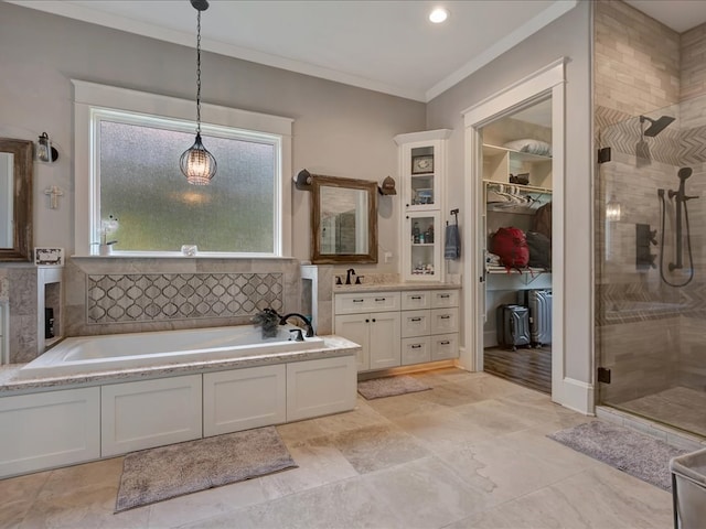 410 Brentwood Dr, Lufkin, TX 75901 - full bathroom featuring a shower stall, vanity, a garden tub, ornamental molding, and a spacious closet
