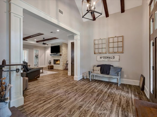 410 Brentwood Dr, Lufkin, TX 75901 - entrance foyer with wood finished floors, a stone fireplace, beamed ceiling, a chandelier, and a high ceiling