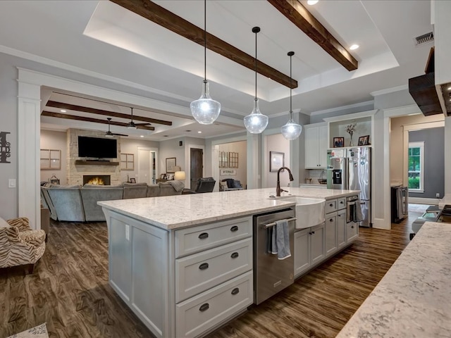 410 Brentwood Dr, Lufkin, TX 75901 - kitchen featuring stainless steel appliances, a raised ceiling, dark wood-type flooring, beam ceiling, and a fireplace