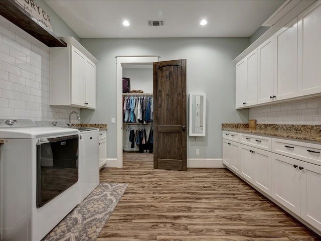 410 Brentwood Dr, Lufkin, TX 75901 - washroom with cabinet space, light wood-style floors, recessed lighting, and washing machine and dryer