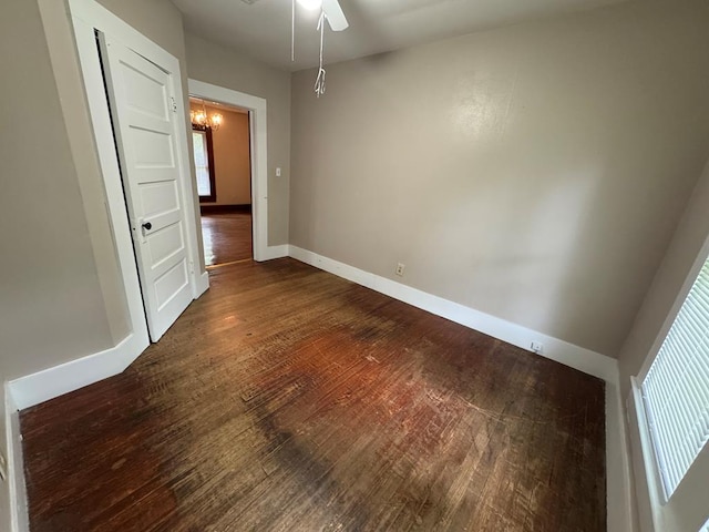 empty room with ceiling fan, baseboards, and dark wood-style flooring
