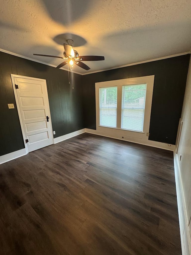 unfurnished room with baseboards, a ceiling fan, dark wood-style floors, and a textured ceiling