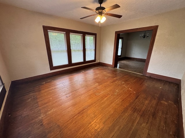 unfurnished room with wood-type flooring, a textured wall, baseboards, and ceiling fan
