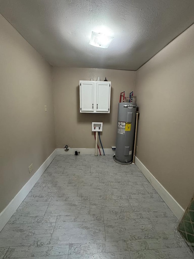 laundry room with baseboards, water heater, cabinet space, and washer hookup