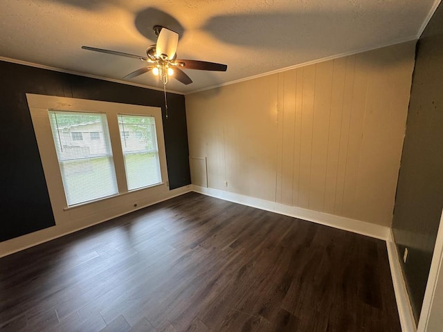 spare room featuring a ceiling fan, a textured ceiling, dark wood finished floors, baseboards, and ornamental molding