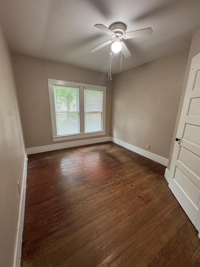 unfurnished room with dark wood finished floors, baseboards, and a ceiling fan