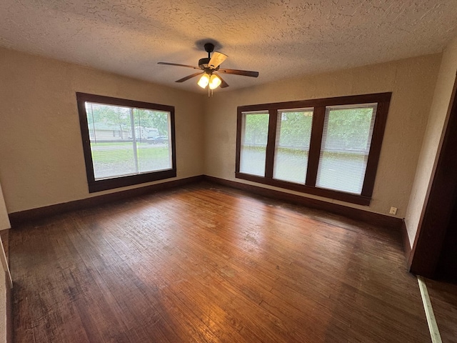 spare room featuring wood finished floors, a ceiling fan, and plenty of natural light