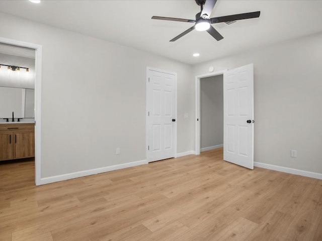 unfurnished bedroom with light wood-type flooring, ensuite bath, ceiling fan, and sink