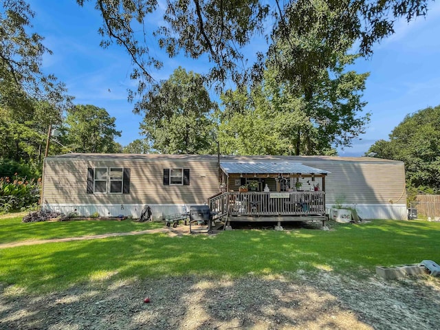 rear view of property with a lawn and a wooden deck