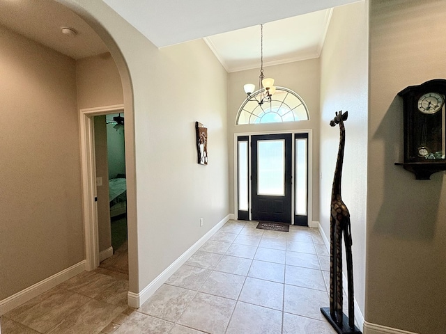 300 Deer Trace Blvd, Diboll, TX 75941 - foyer entrance with crown molding, arched walkways, a chandelier, light tile patterned flooring, and a towering ceiling