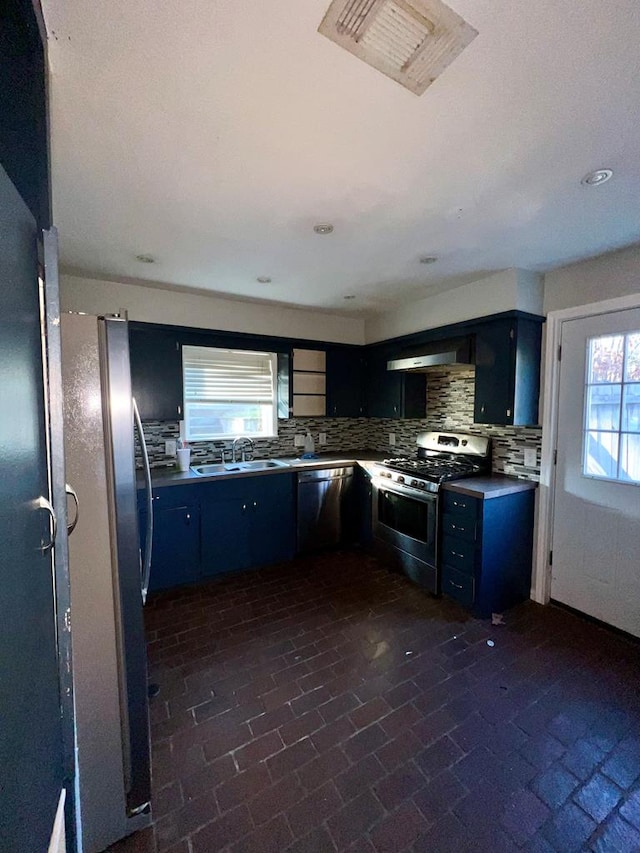 kitchen with decorative backsplash, appliances with stainless steel finishes, range hood, and sink