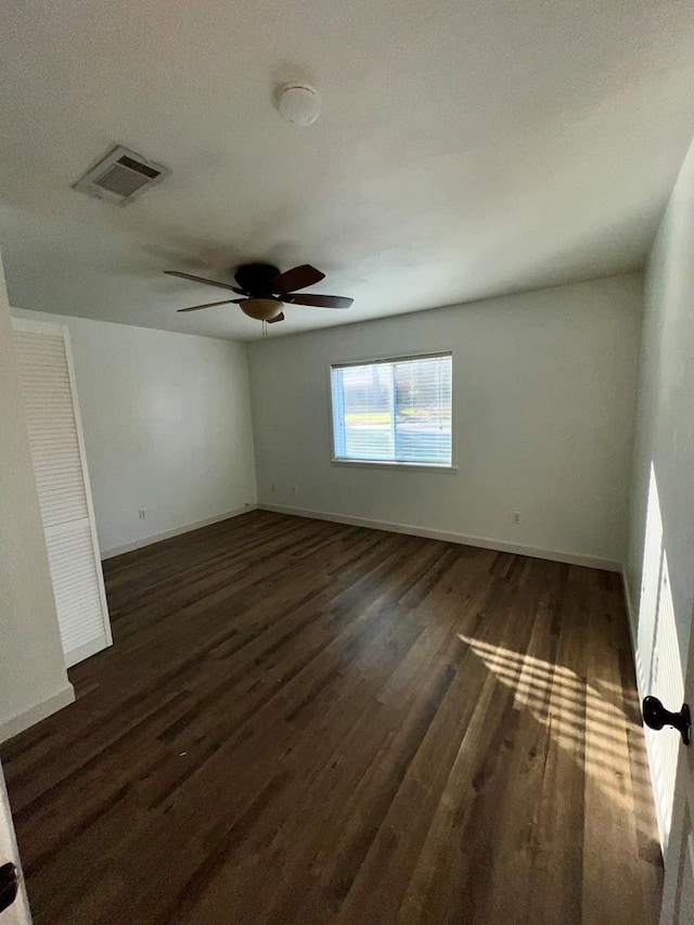 spare room with ceiling fan and dark wood-type flooring