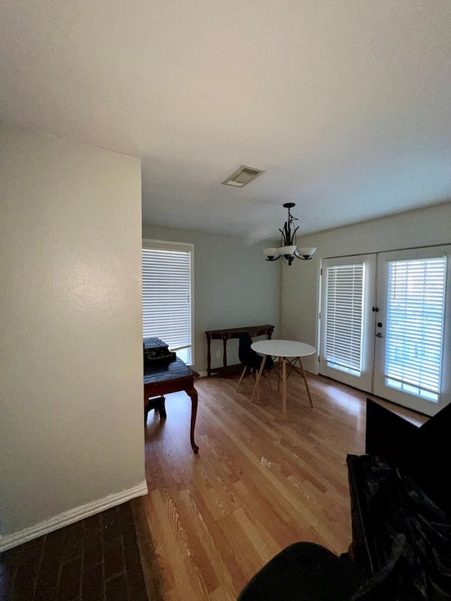 dining space with wood-type flooring and a chandelier