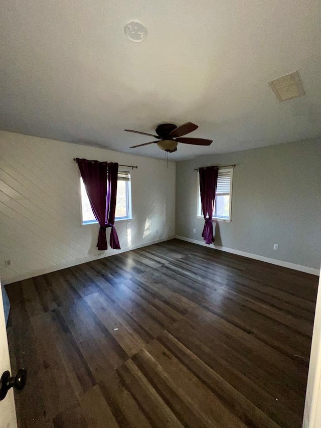 spare room with dark hardwood / wood-style flooring and ceiling fan