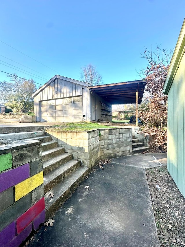 view of patio with a garage and an outbuilding