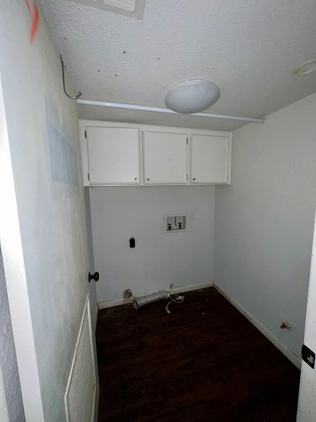 washroom with cabinets, hookup for a washing machine, a textured ceiling, dark hardwood / wood-style floors, and hookup for a gas dryer