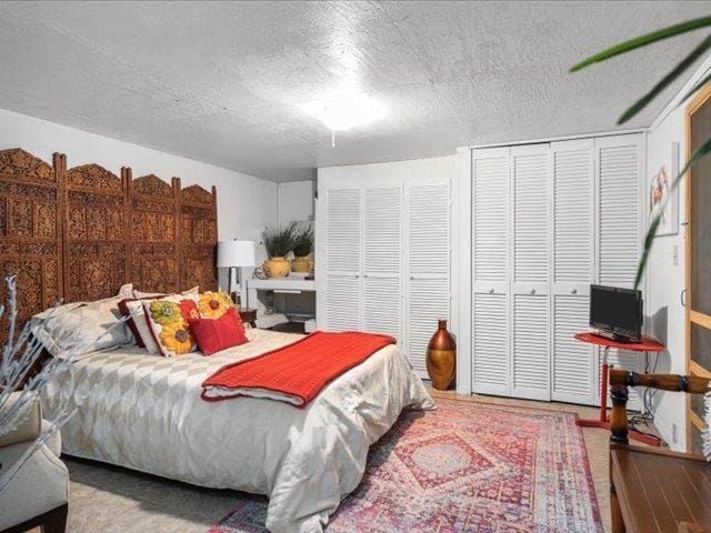 bedroom featuring multiple closets and a textured ceiling