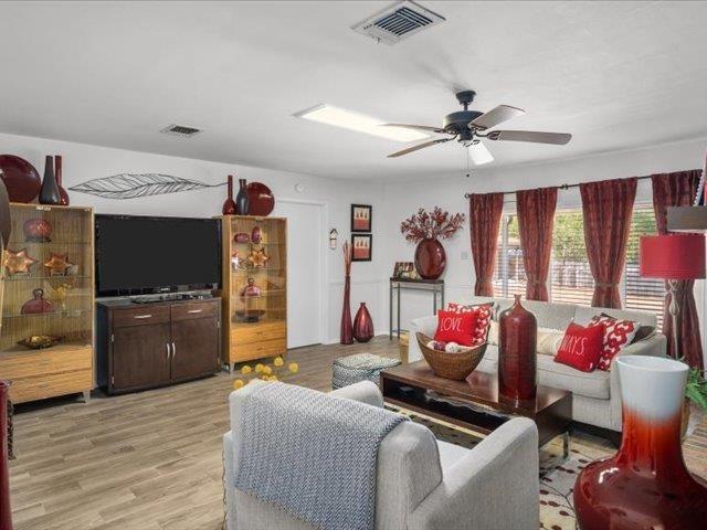 living room featuring light hardwood / wood-style flooring and ceiling fan