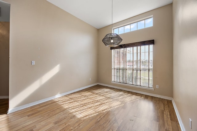 empty room featuring hardwood / wood-style flooring and lofted ceiling