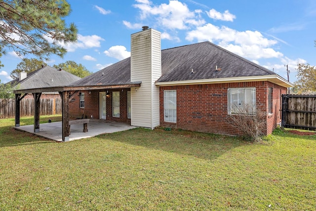 rear view of property featuring a lawn and a patio