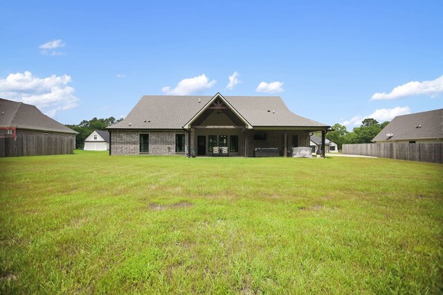 rear view of property with a lawn and fence