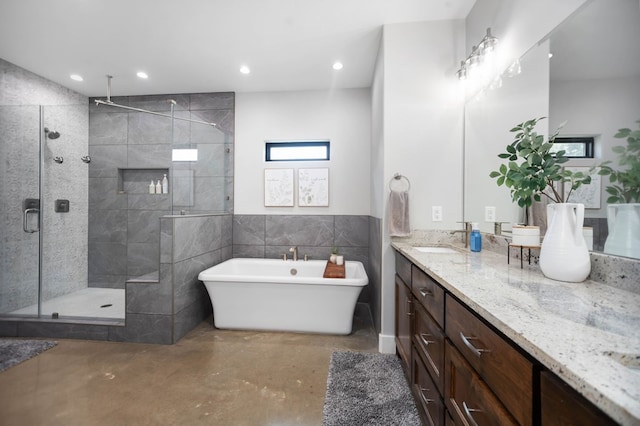 full bathroom featuring vanity, concrete floors, recessed lighting, a freestanding tub, and a stall shower