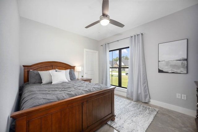 bedroom with baseboards, a ceiling fan, and concrete flooring