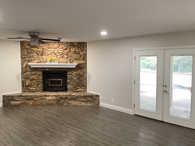 unfurnished living room with french doors, dark hardwood / wood-style flooring, a wood stove, and ceiling fan