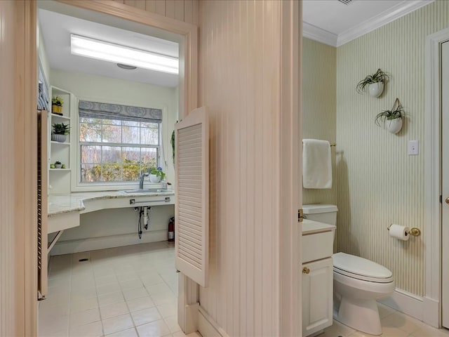 bathroom with tile patterned floors, vanity, toilet, and crown molding