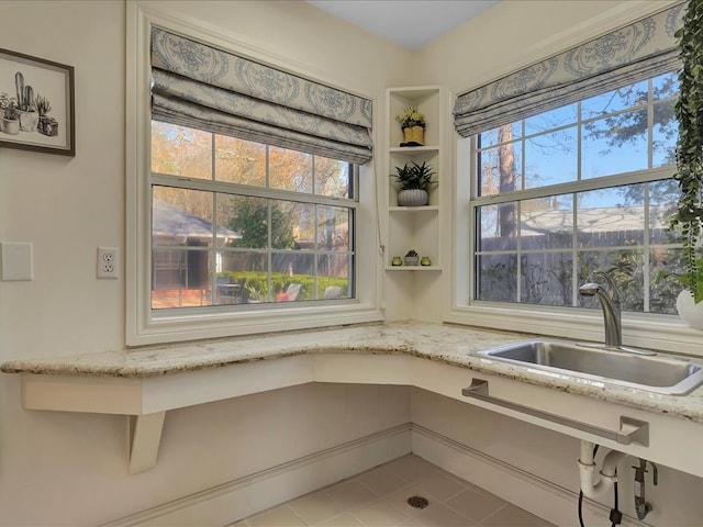 interior details featuring light stone countertops and sink