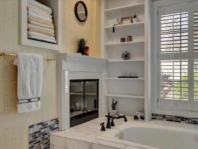 bathroom with built in features and a bath