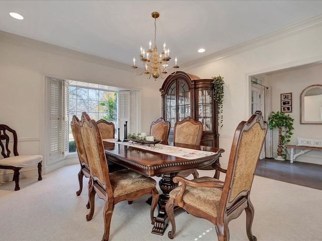 dining space with a notable chandelier, light hardwood / wood-style floors, and ornamental molding